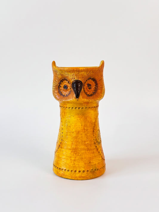 Mustard yellow ceramic owl with circular orange eyes, dark beak, and impressed dotted decoration