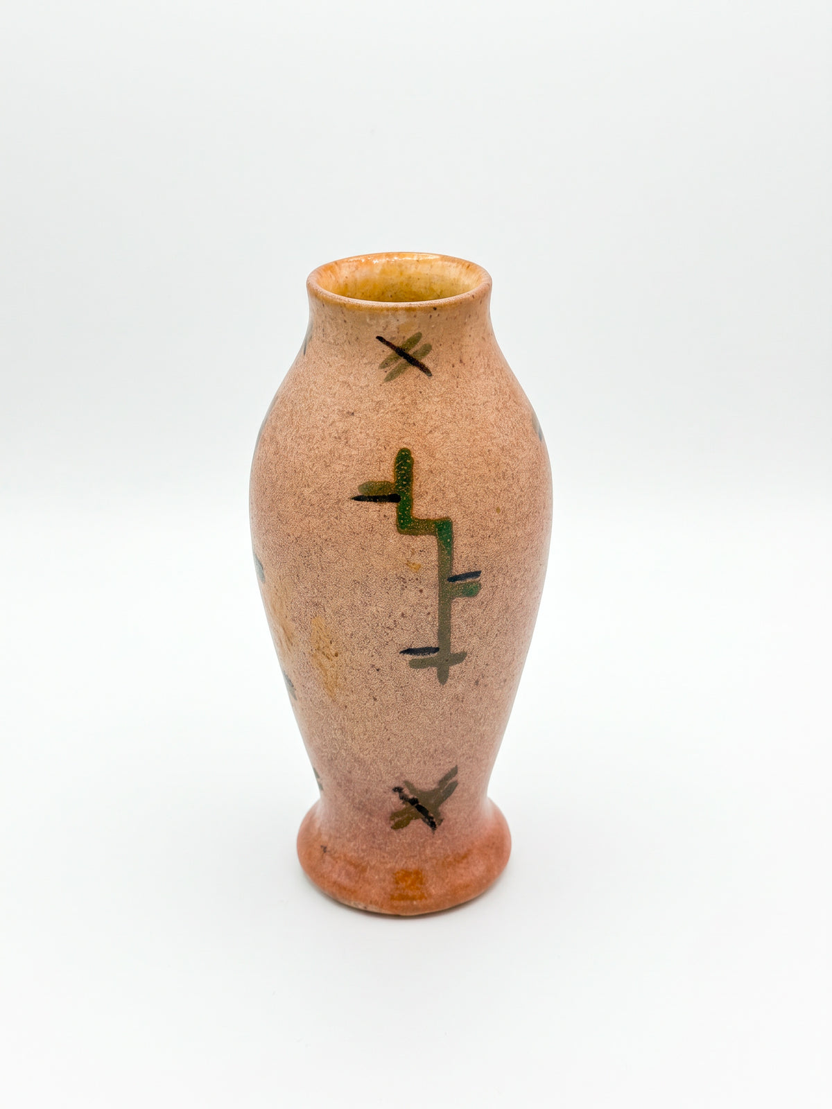 Peach speckled vase with green and brown abstract decoration on a white background