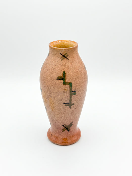 Peach speckled vase with green and brown abstract decoration on a white background